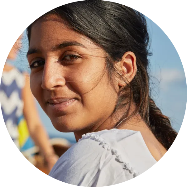 young adult woman wearing a light blue shirt looking at the camera, cropped in a circle