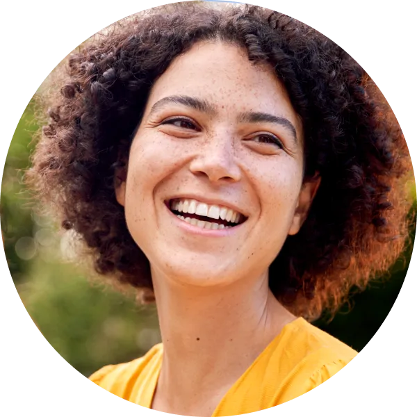 woman in a yellow shirt with short curly hair cropped in a circle