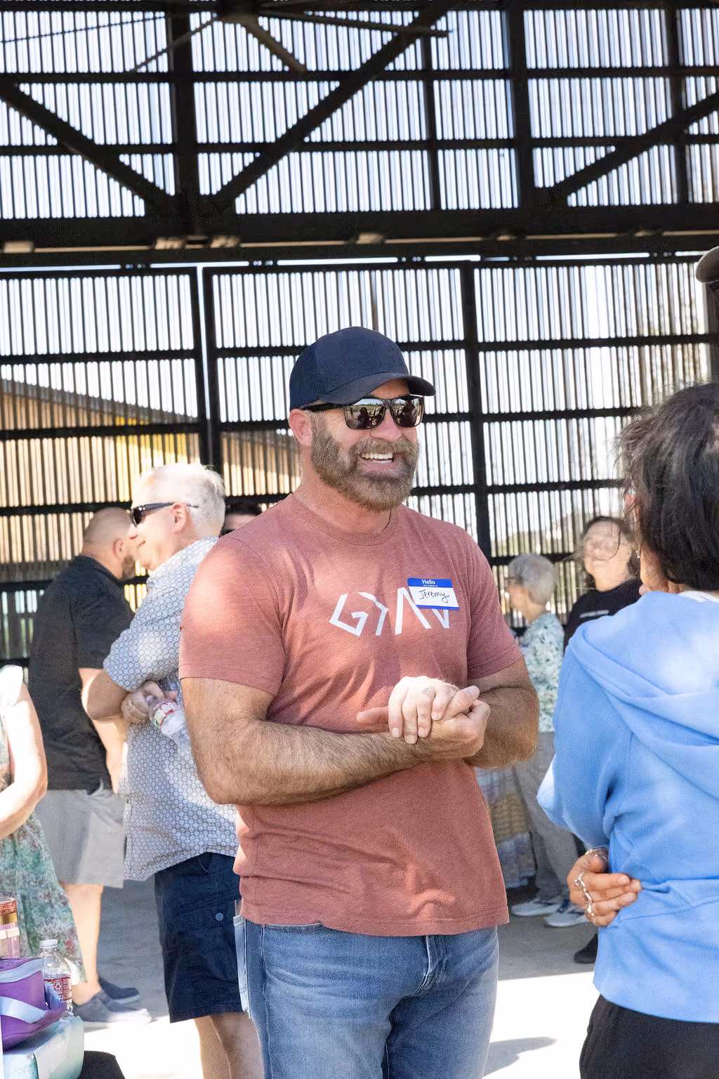 A smiling man talking with others inside a barn venue