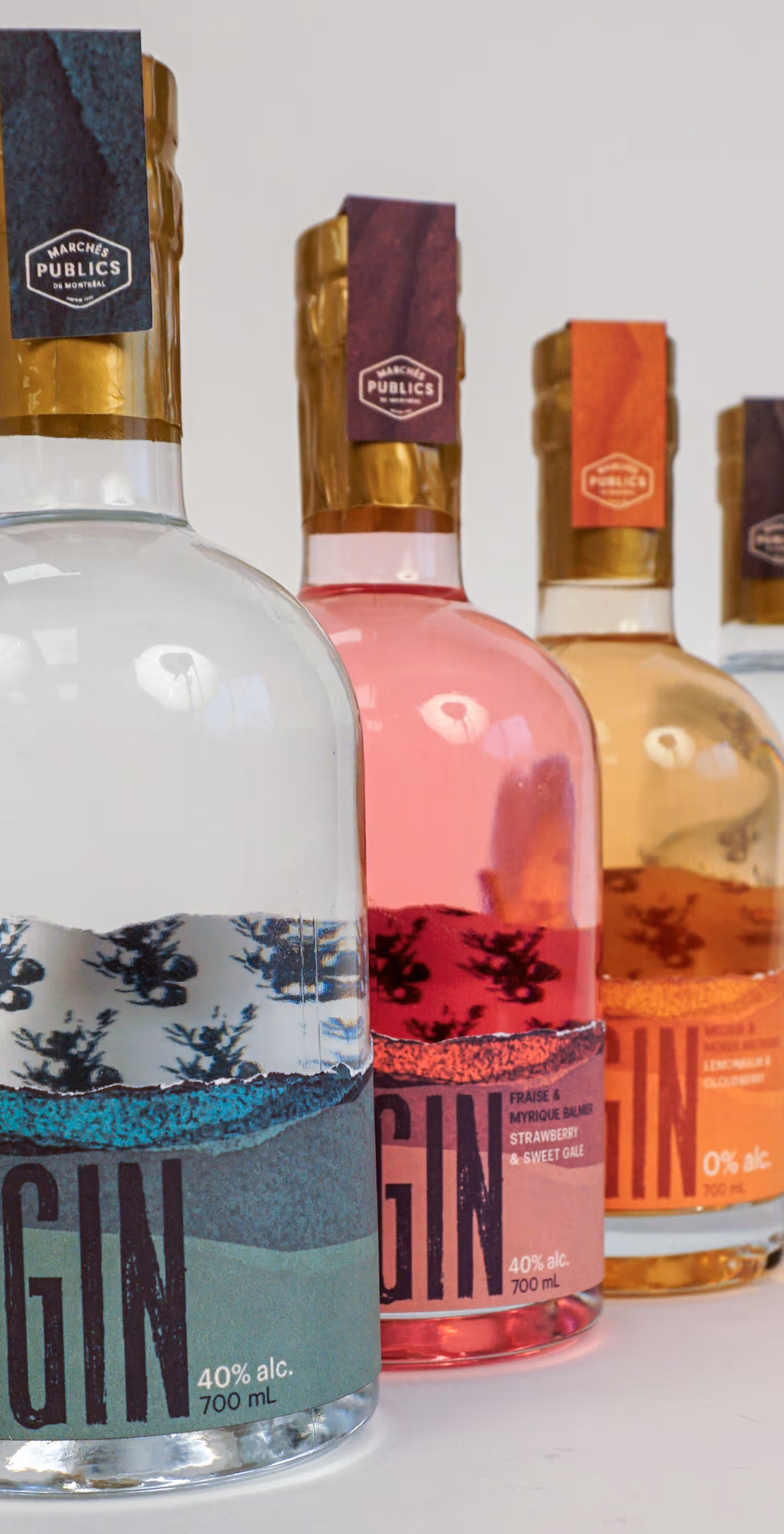 Four bottles of Marchés Publics gin in clear, pink, orange, and clear liquids with gold caps.
