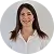 Portrait of a smiling woman with long dark hair wearing a white shirt against a white background.