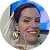 Smiling woman wearing blue headband and white earrings with a blurred background.