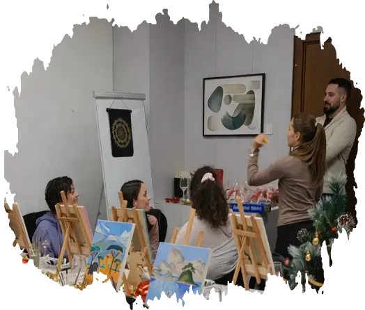 Group of people in a painting class with easels and artwork, woman gesturing toward man.