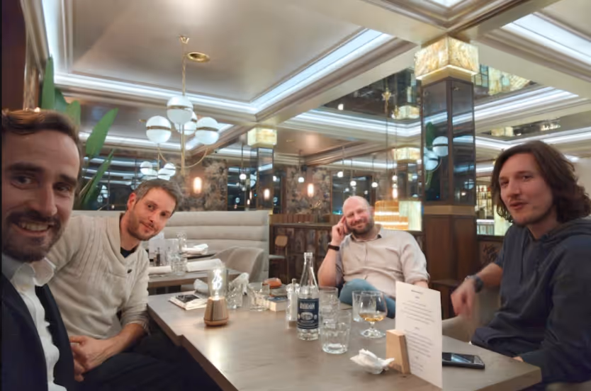 The four members of the Nagome team gathered around a table