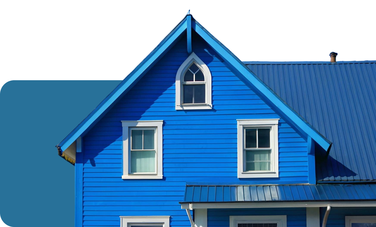 Blue house with white-trimmed windows and a blue metal roof under clear sky.