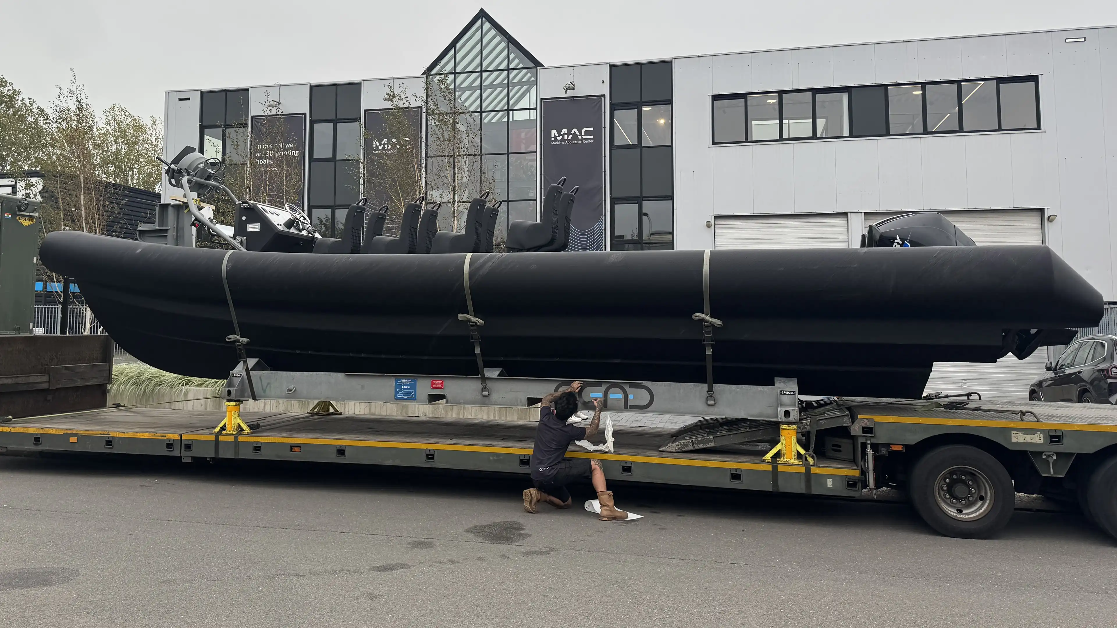 Large 3D printed RIB secured on a low-loader trailer for transport
