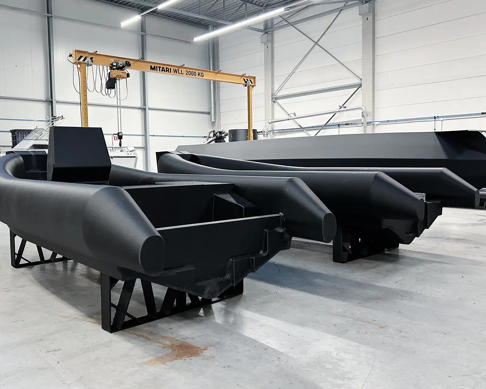 Several 3D printed HDPro hulls on stands in the Dutch Boat Factory production hall