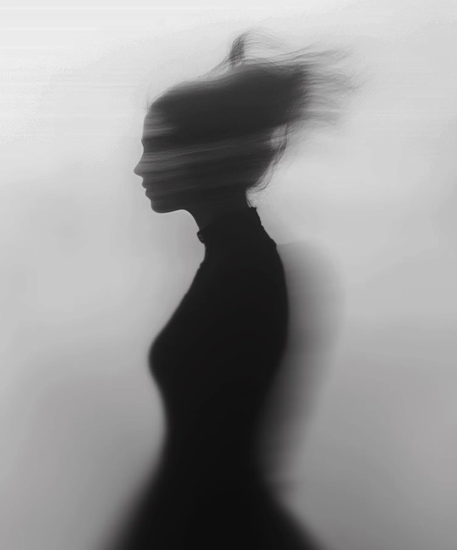 Black silhouette of a woman in profile with blurred hair and a ghostly second outline behind her.
