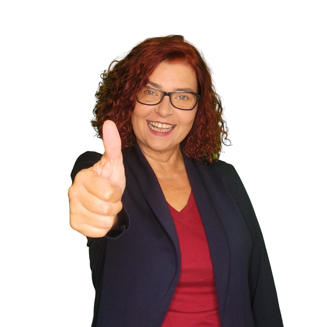 Frau mit roten Locken und Brille zeigt lächelnd Daumen hoch.
