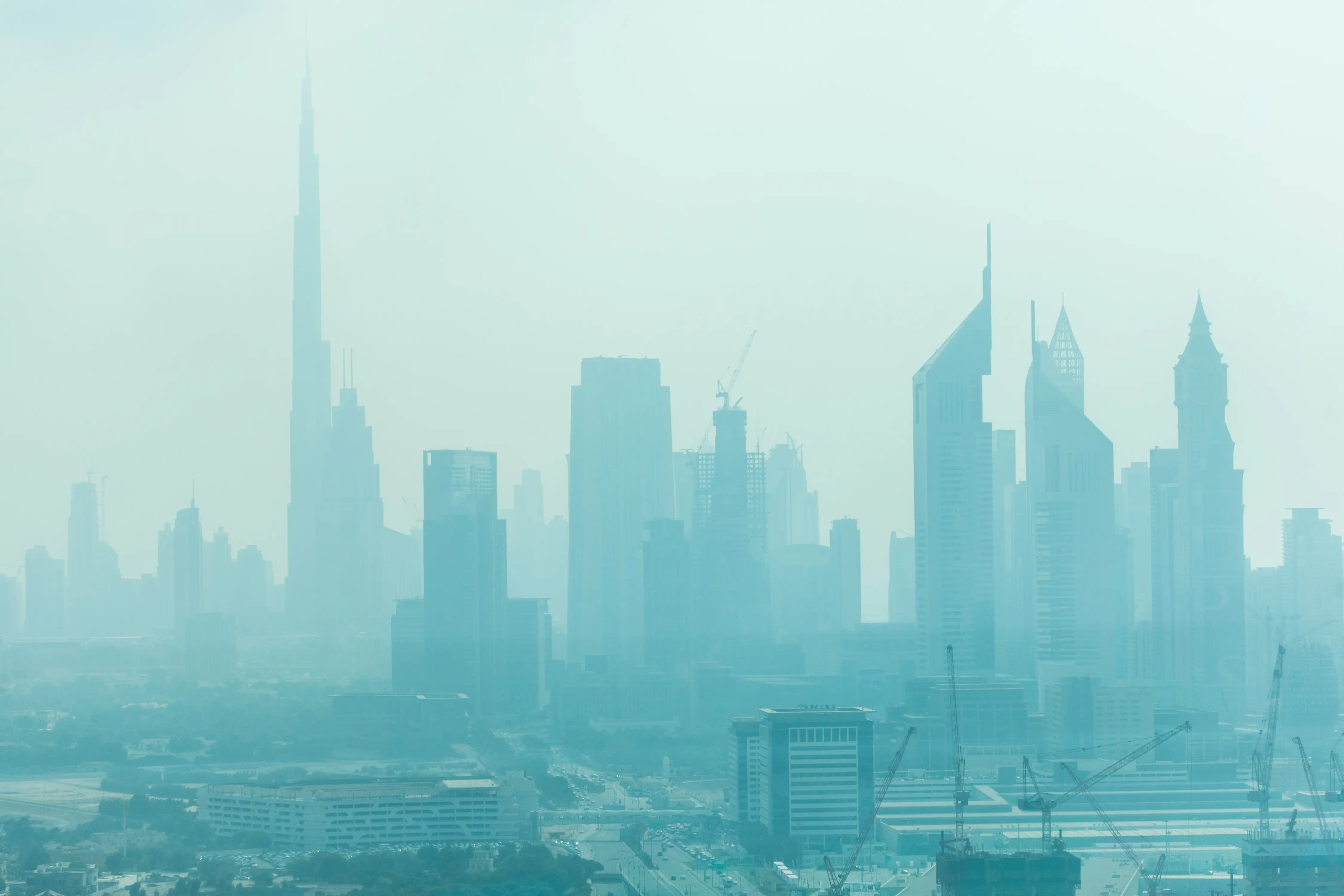Dubai skyline covered by sand dust and haze, highlighting uncertainty in the Dubai real estate market during the 2026 property downturn and investment crisis analysis.