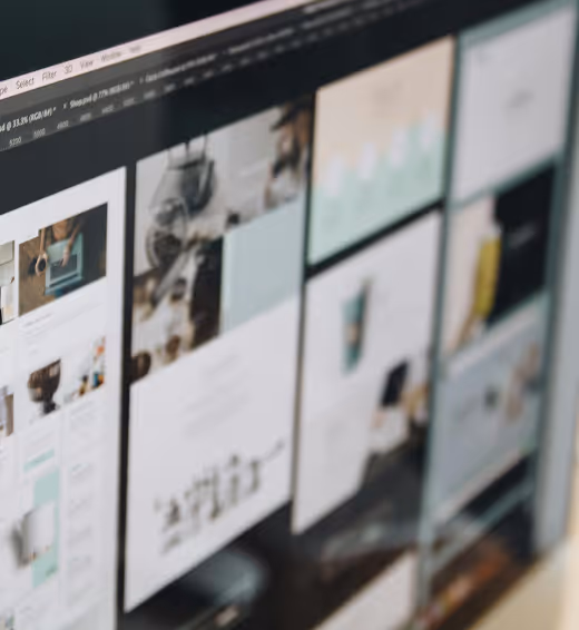 Computer screen showing blurred website or graphic design layouts in a grid view.