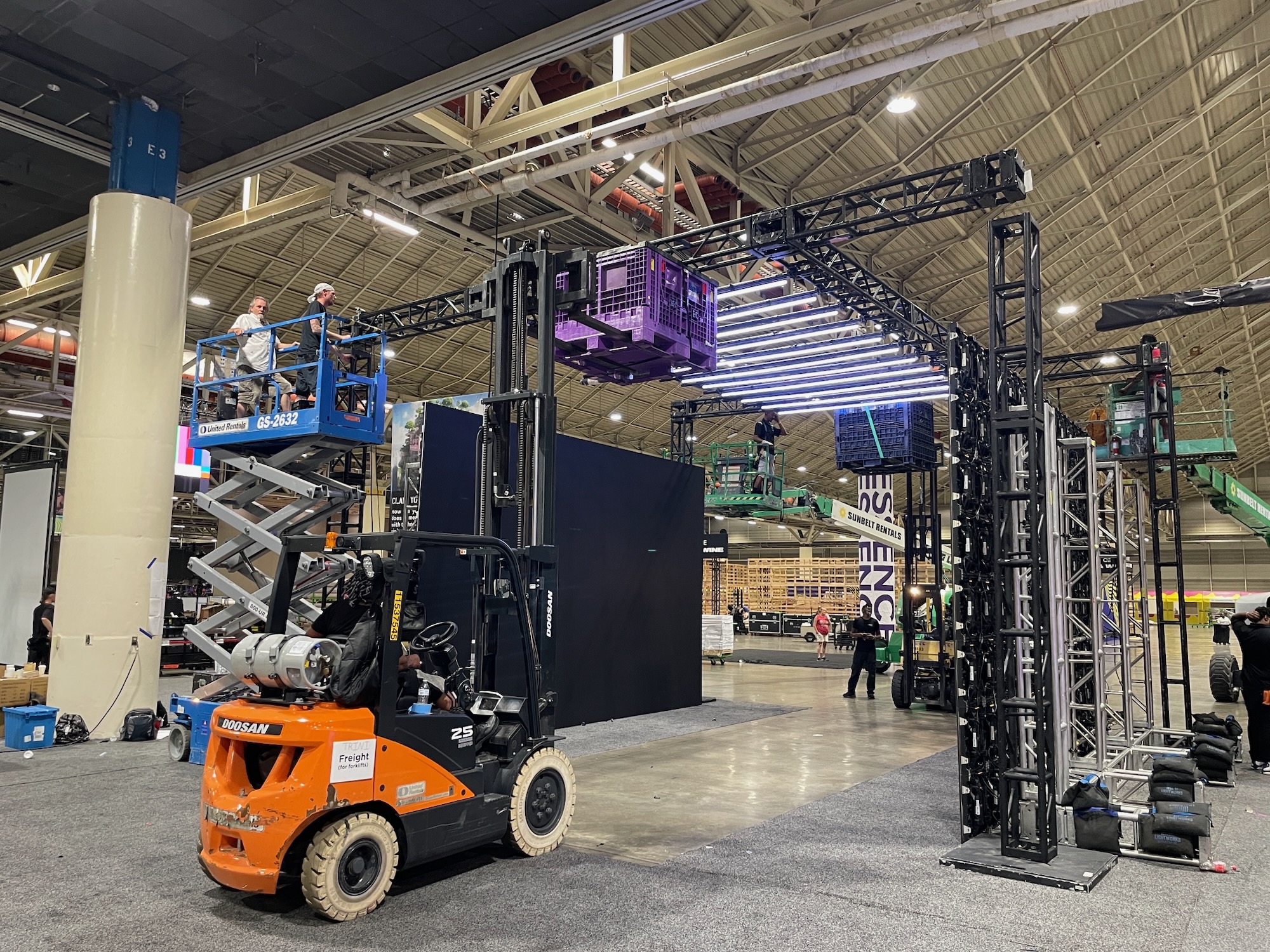 Production crew setting up rigging and equipment for a live event.