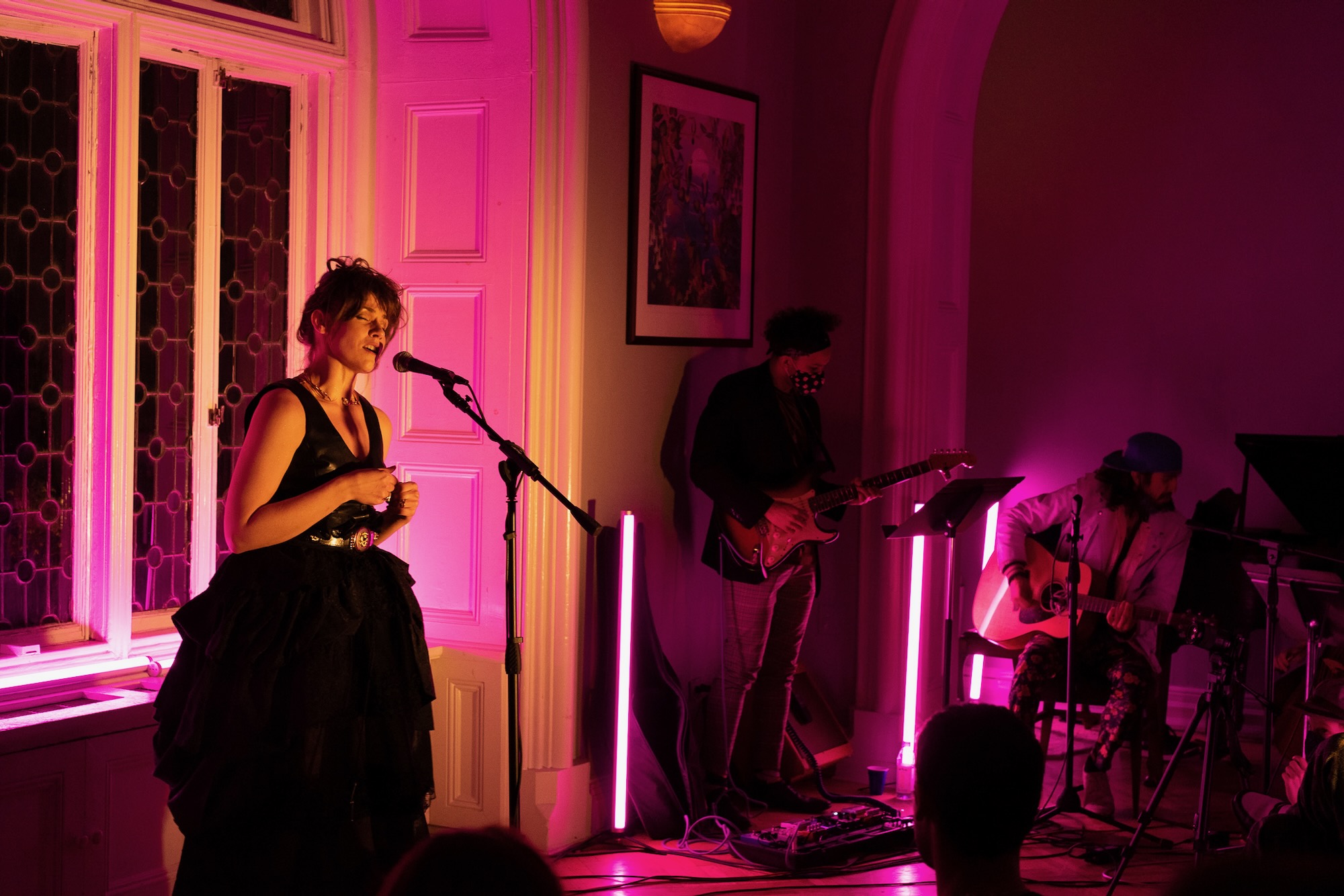 Singer at microphone in pink stage lighting