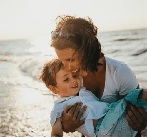 a woman carries her son in her arms