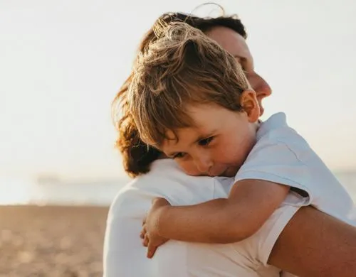 a woman hugs a boy