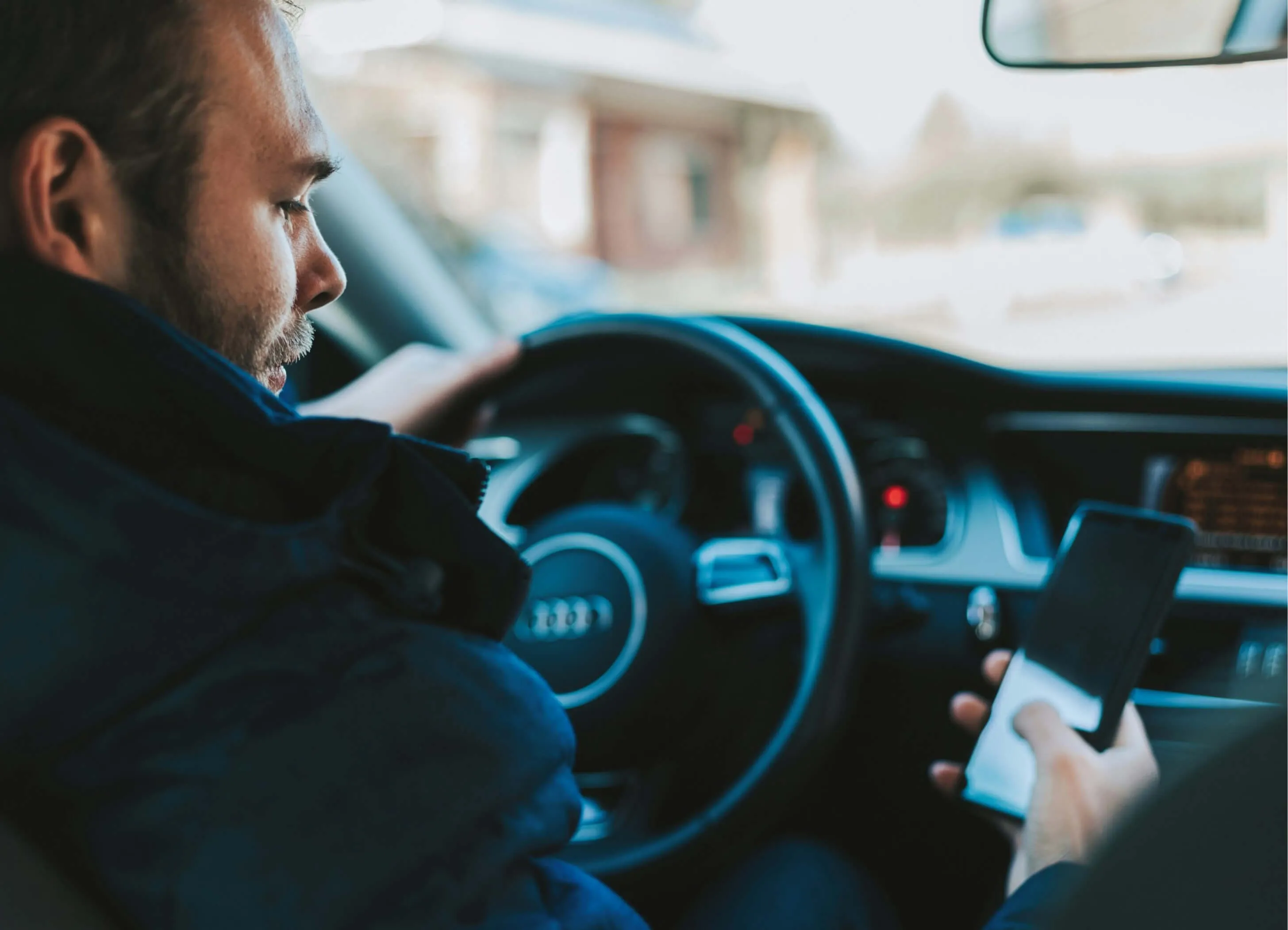 the man behind the wheel is looking at the phone