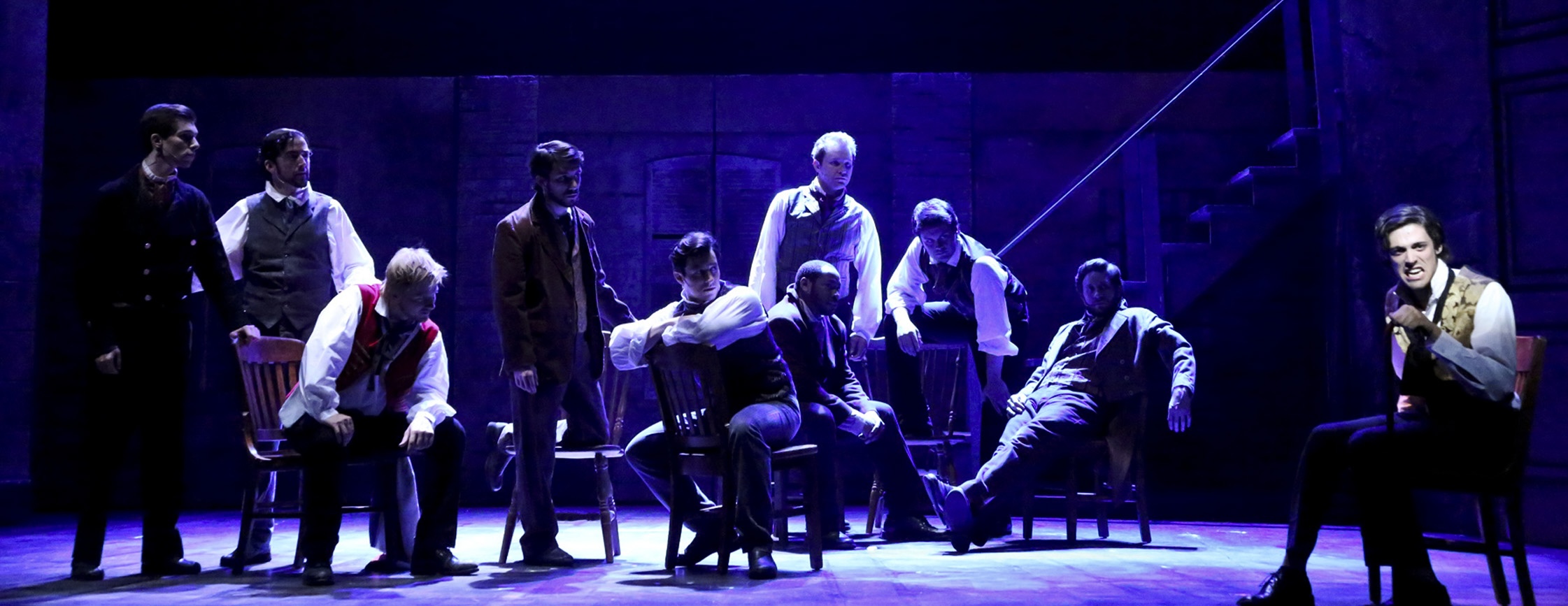 Marius stands apart in a pool of light as the students appear around him in “Empty Chairs at Empty Tables” from Les Misérables.