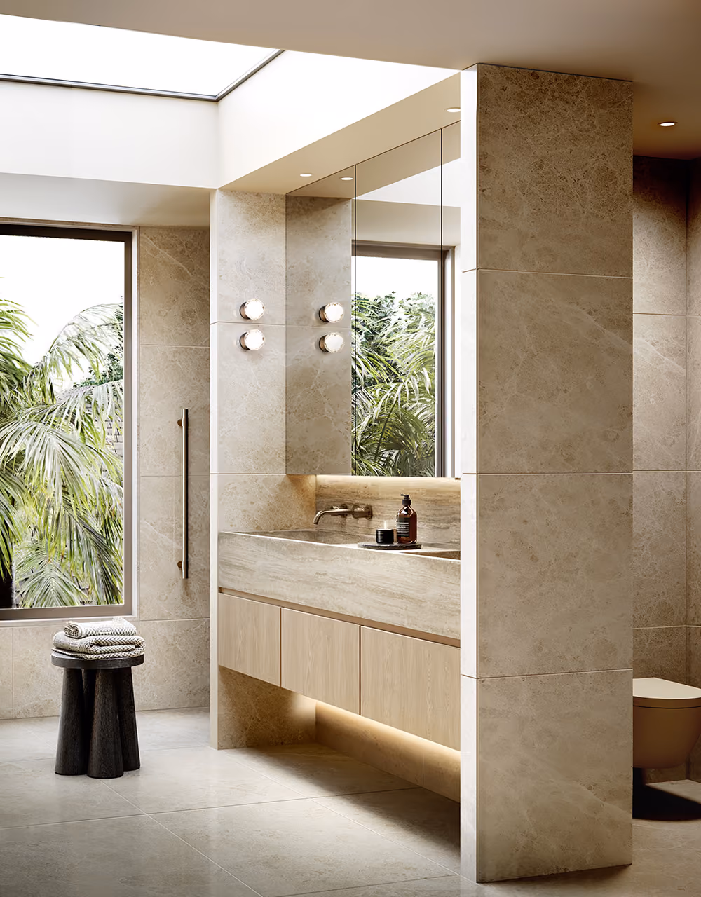 Ensuite bathroom with floor-to-ceiling stone tiling, floating timber vanity and skylight overlooking palm trees