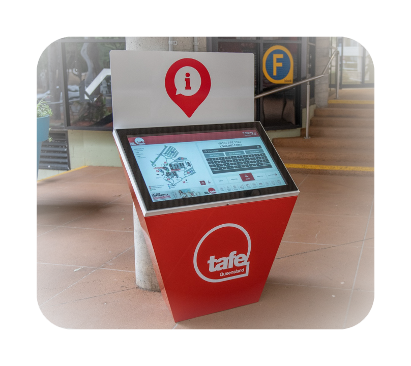 Interactive red and white TAFE Queensland information kiosk with a touchscreen displaying a campus map and search keyboard, located indoors near stairs and a pillar.