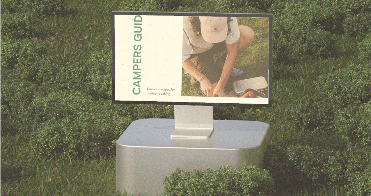 Outdoor digital display in grass showing Camper’s Guide website page.
