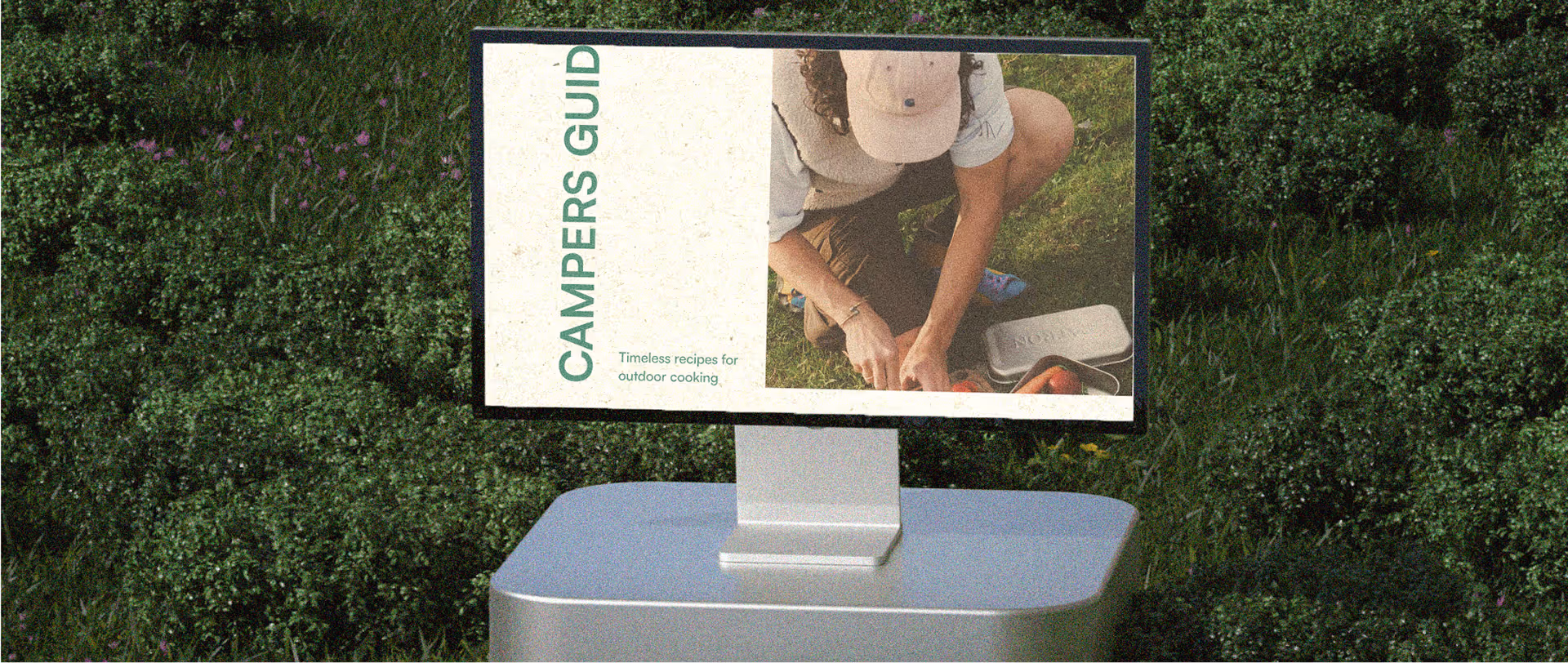 Computer on grass platform, with Campers' Guide website page open.