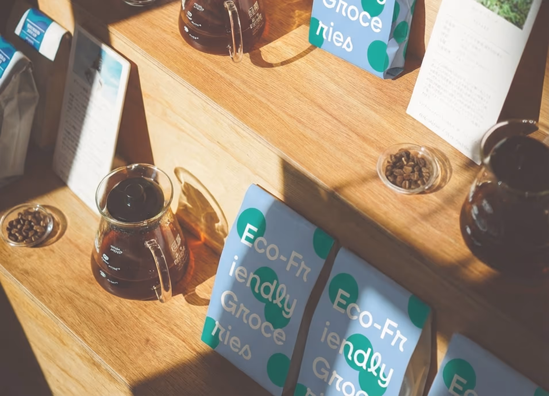 Coffee brewing setup with glass carafes, coffee beans, and eco-friendly grocery bags on wooden shelves.