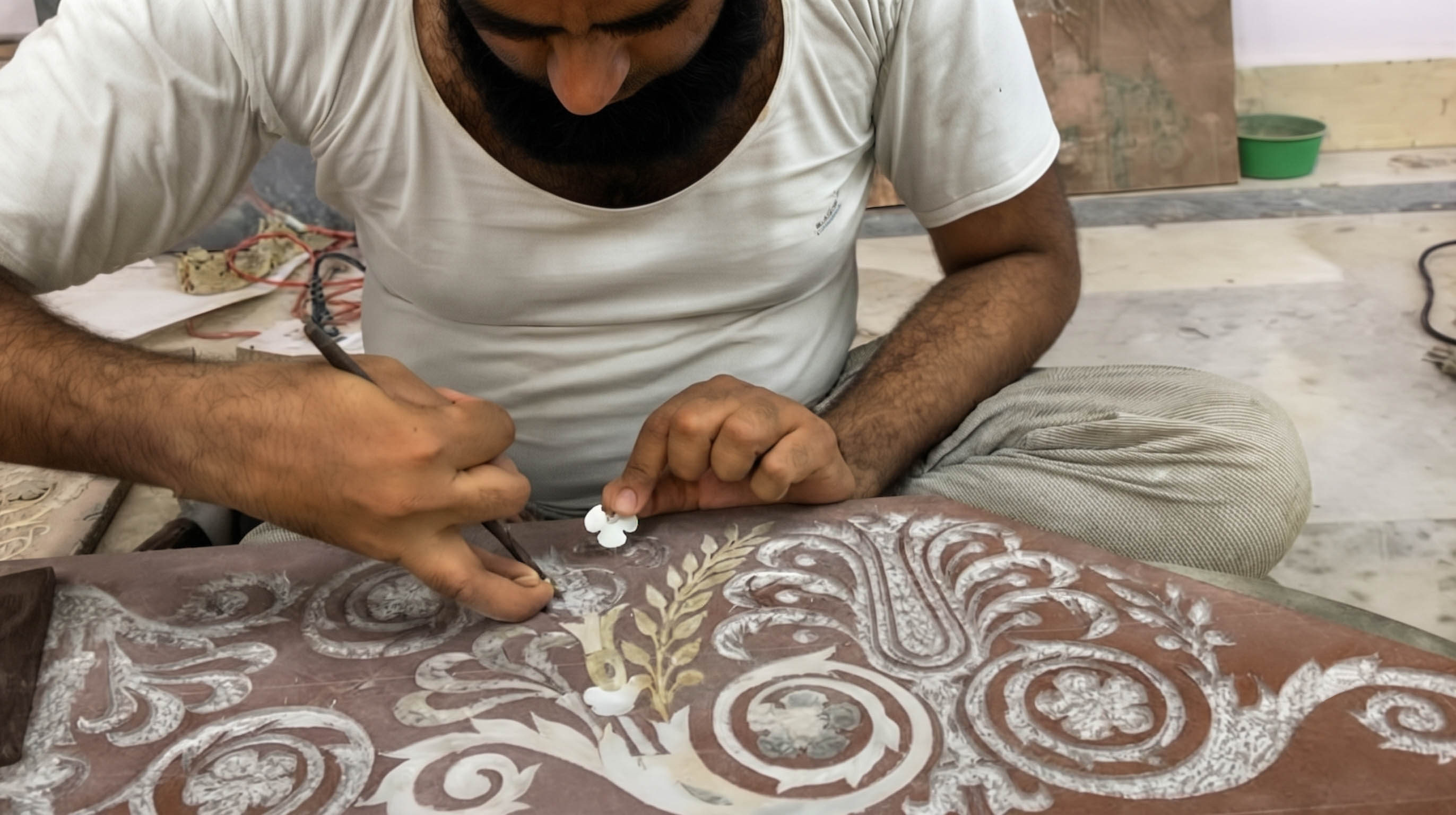 Craftsman chiselling a groove into marble to set a stone in a Pietra Dura inlay