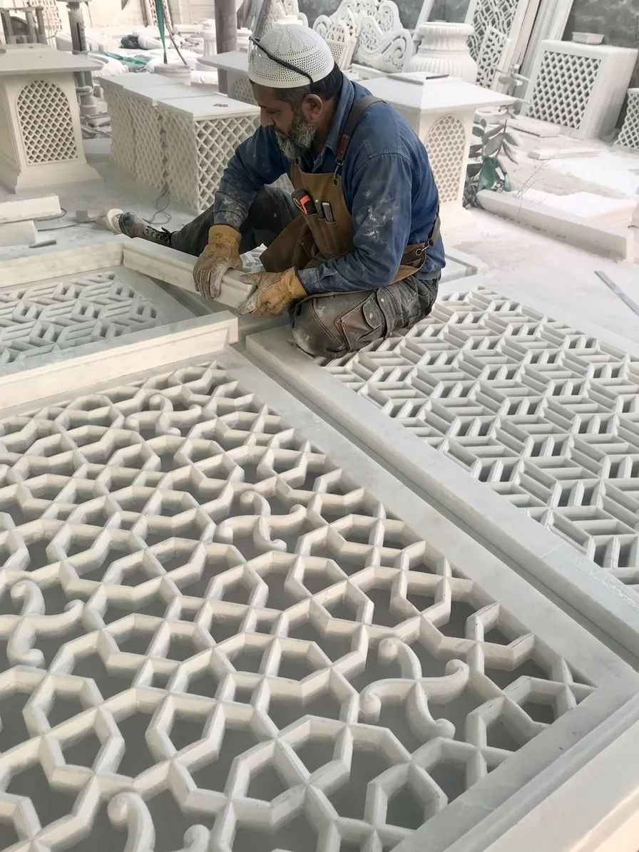 Craftsman seated in the workshop carving a geometric marble jali panel for the Al Mula Residence, Kuwait