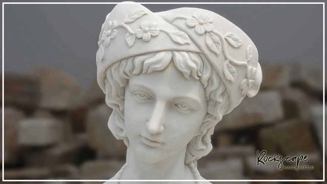 Hand-carved white marble bust of a woman wearing an ornate floral headdress