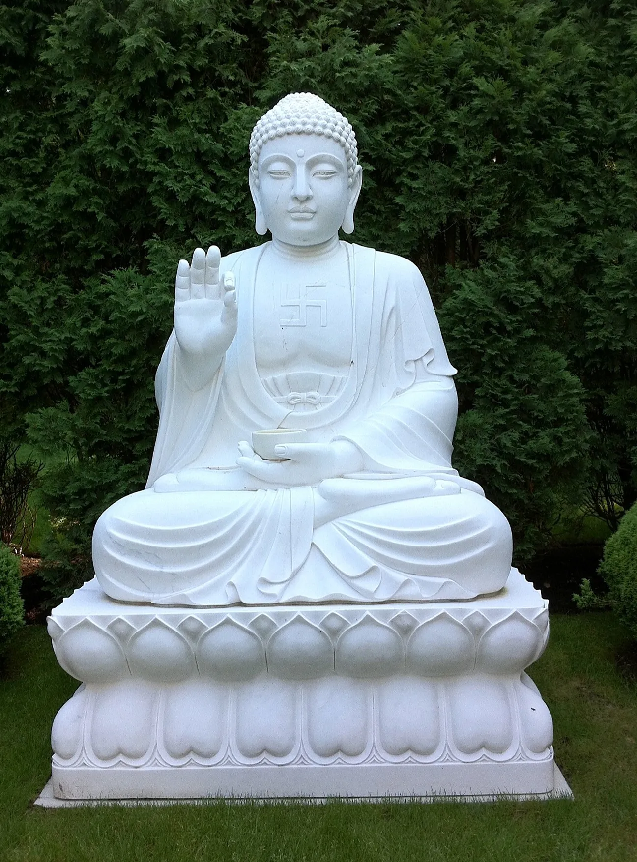 Hand-carved white marble Buddha seated on a lotus throne with a raised blessing hand, The Greenwich Estate