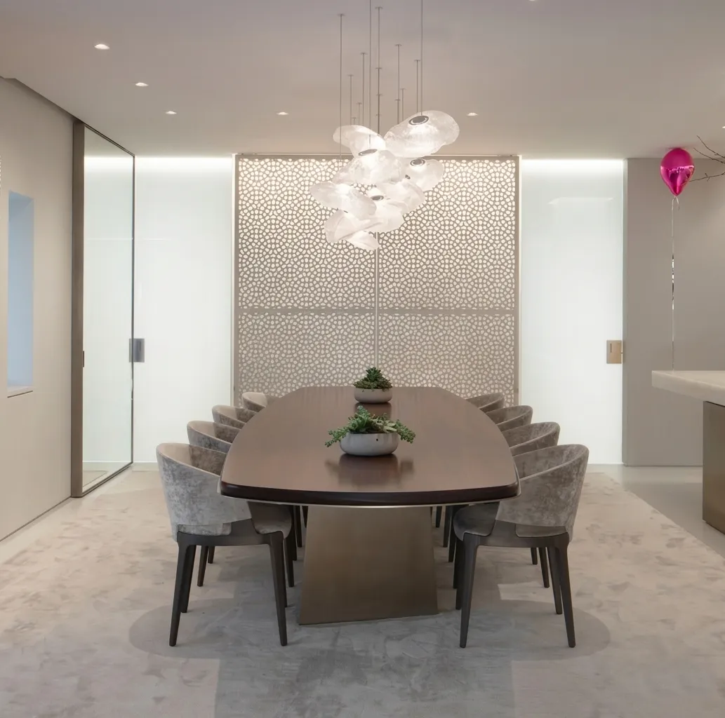 Dining room with a long table in front of a floor-to-ceiling marble jali wall, The Plaza Residence, New York