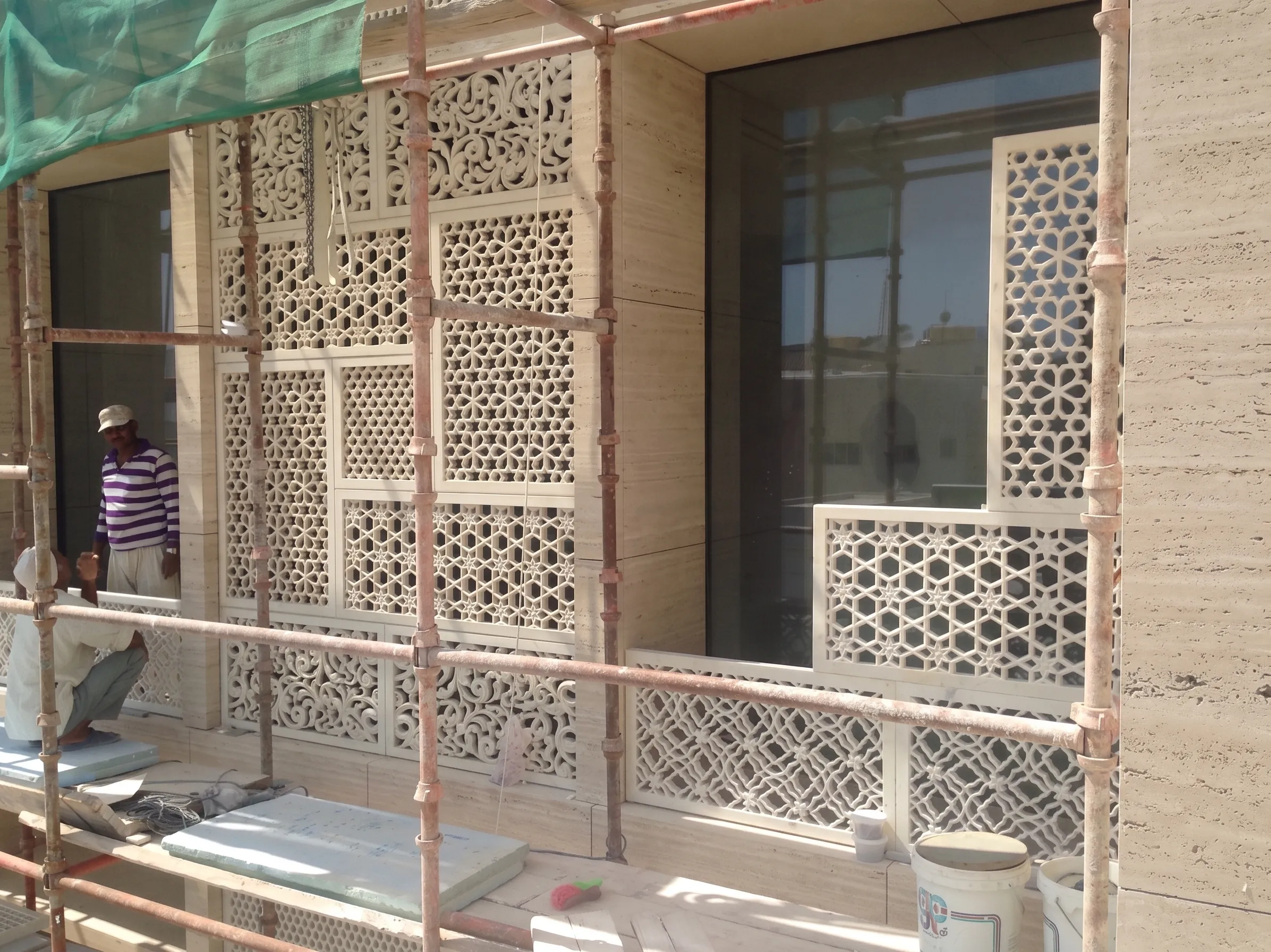Carved stone jali panels being installed behind scaffolding at the Elite Residence, Kuwait