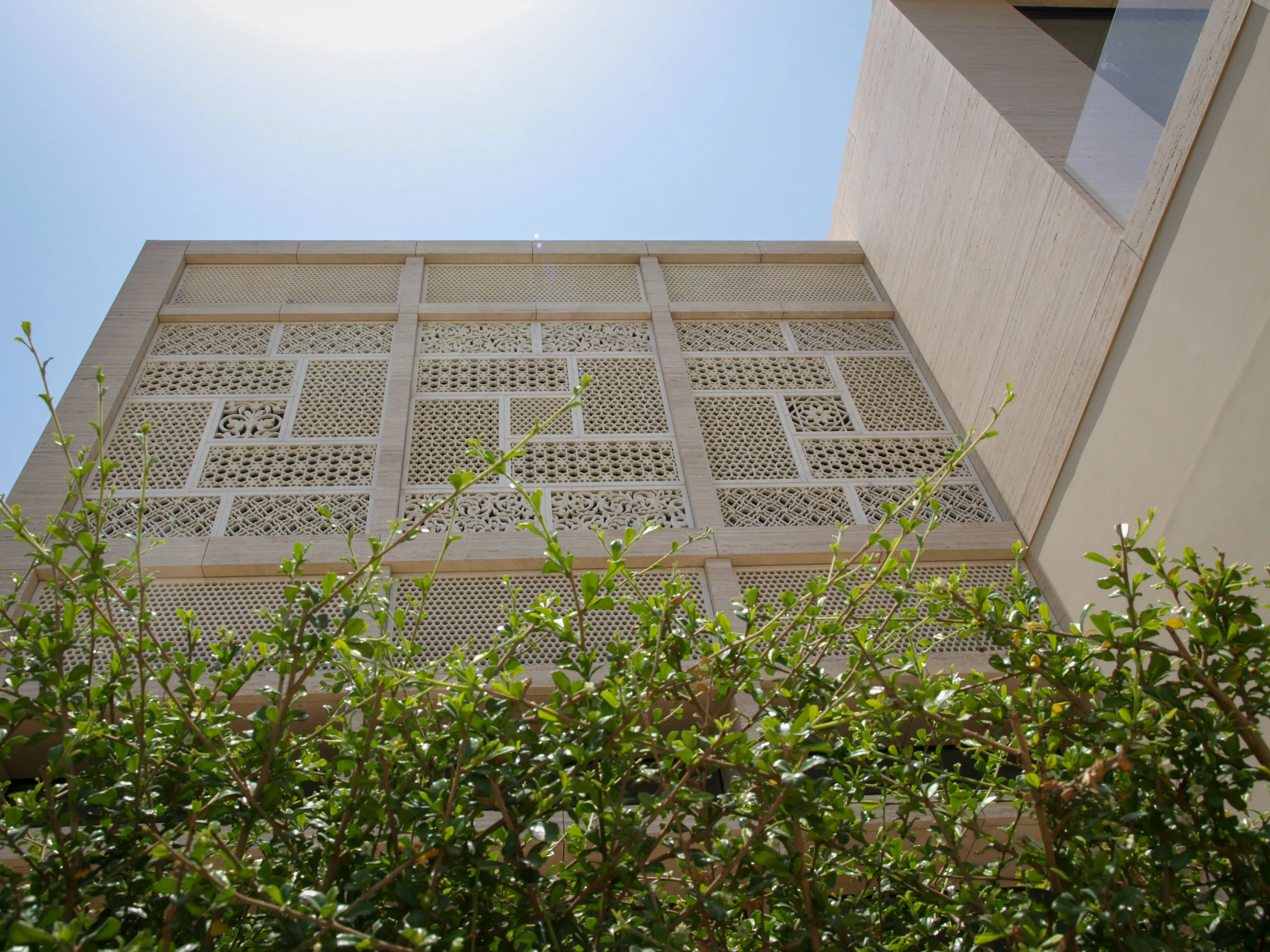 Elite Residence, Kuwait, seen from the garden with mashrabiya panels rising above the hedges