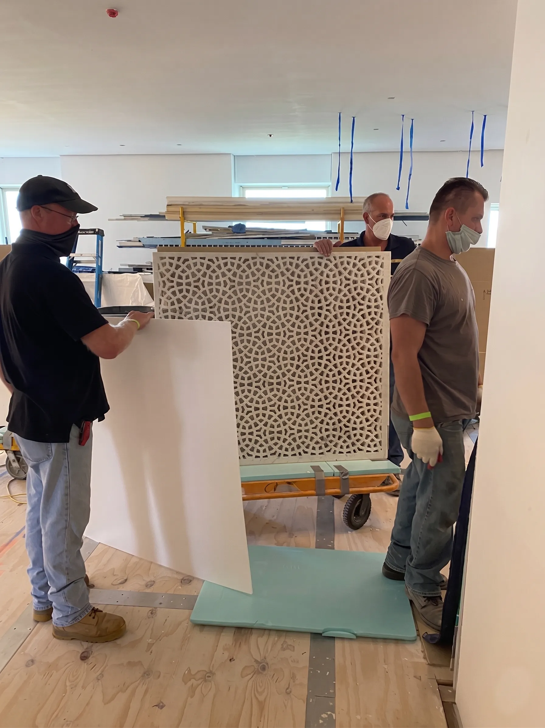 Installers positioning a marble jali panel inside the apartment at The Plaza Residence