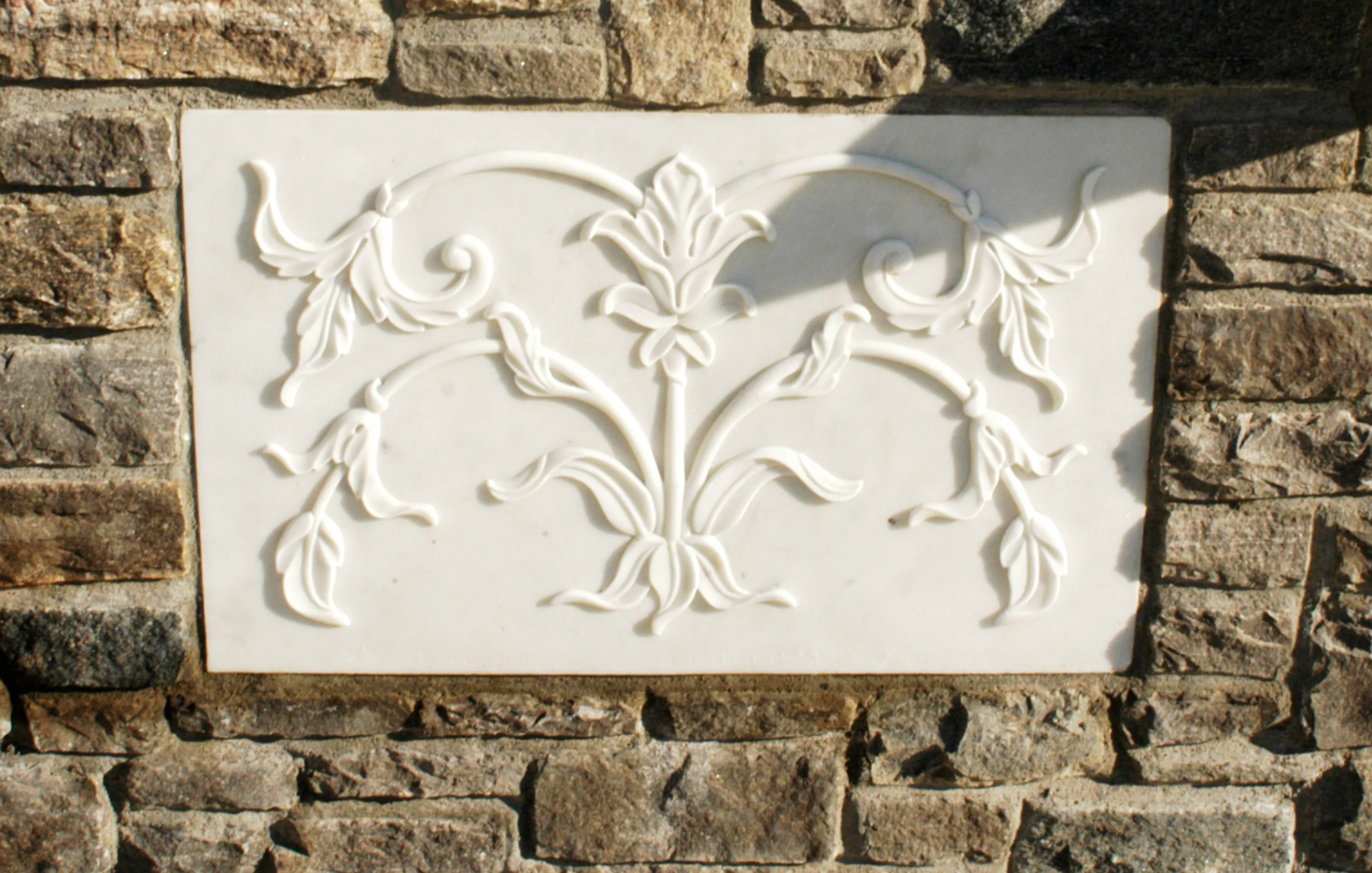 Hand-chiselled marble floral relief panel set into a fieldstone wall, Westport, Connecticut estate