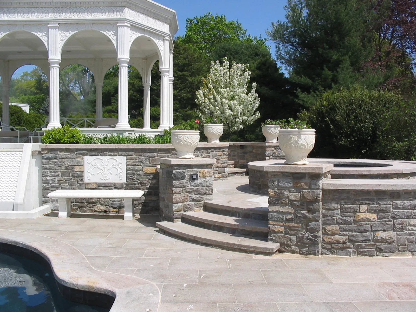 Marble pavilion above curved stone steps, a spa and planted urns, Westport, Connecticut estate
