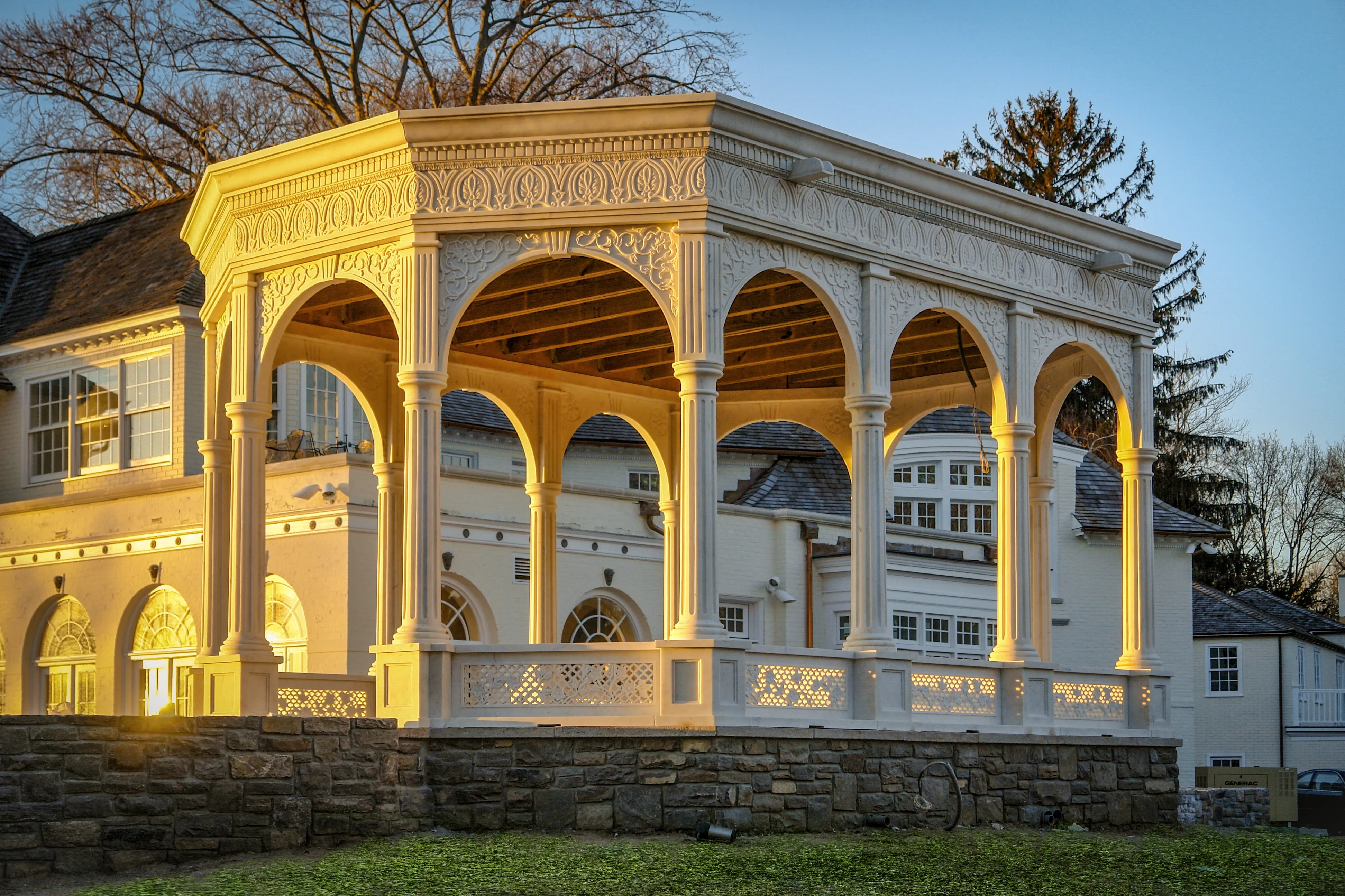 White marble pavilion glowing in golden evening light beside the main house, Westport, Connecticut estate