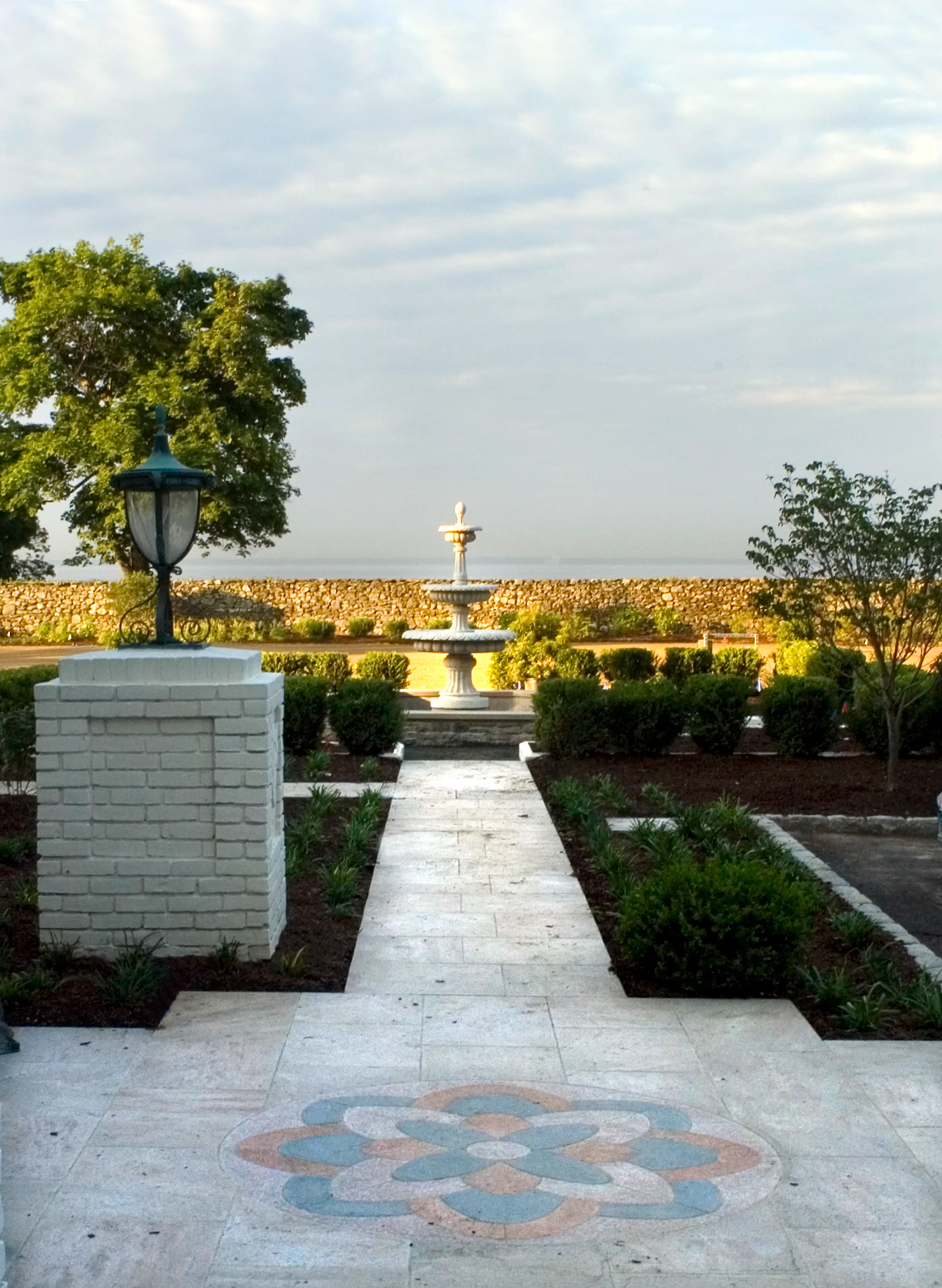 Marble path with an inlaid medallion leading past a lamp post to a distant fountain, Westport, Connecticut estate