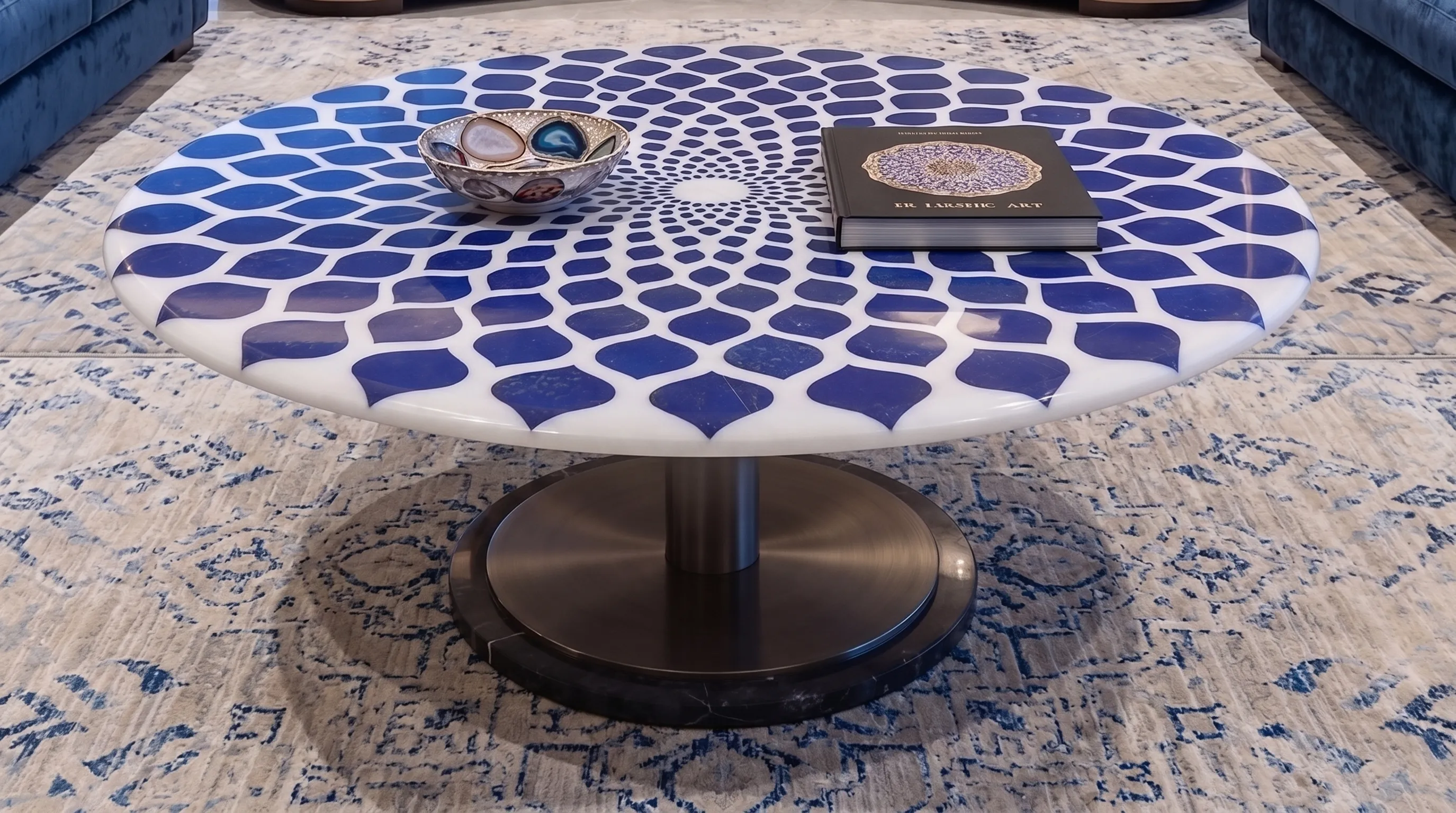 Low round table with a white marble top inlaid with lapis lazuli petals on a blue-and-white rug