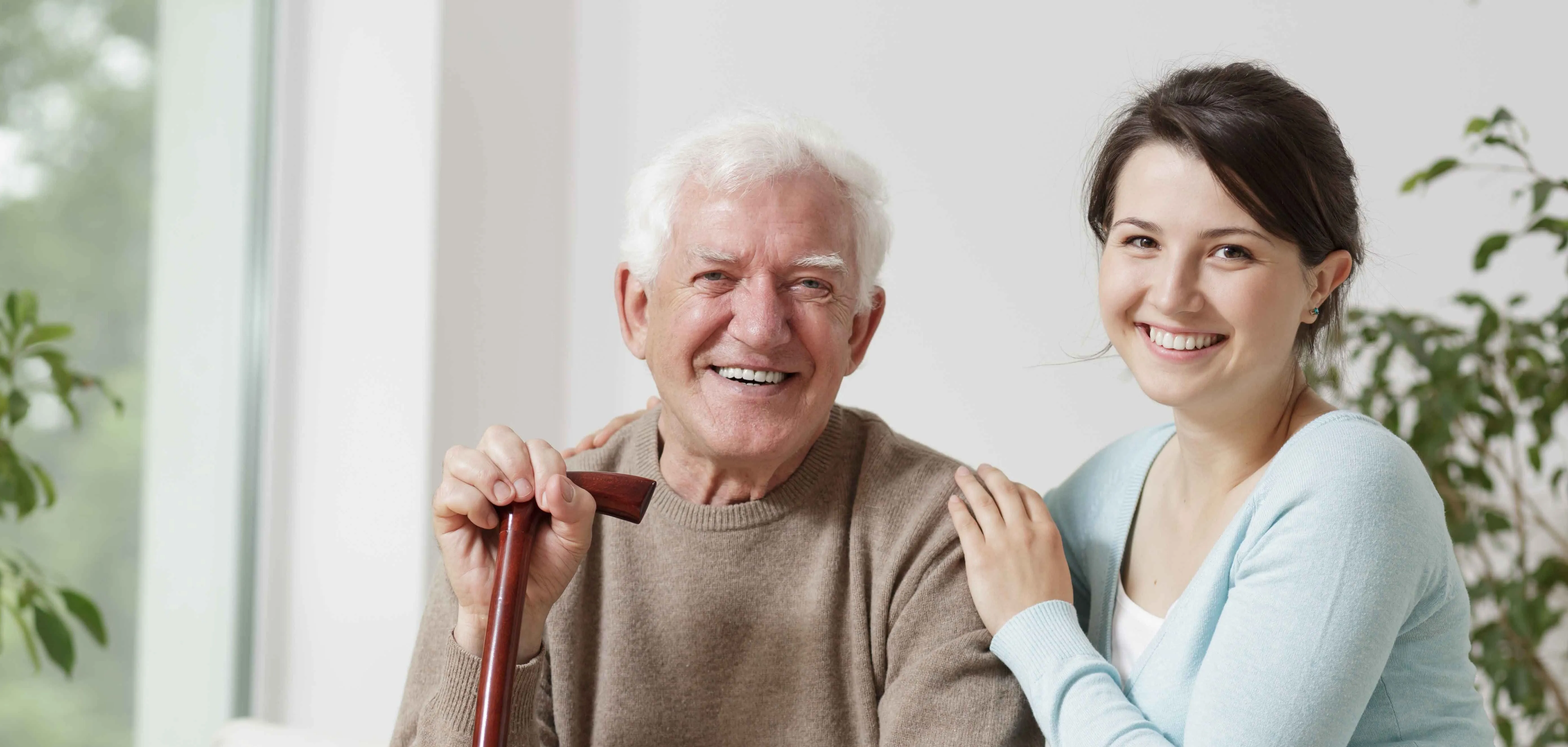 Younger woman puts hand on elderly mans shoulder