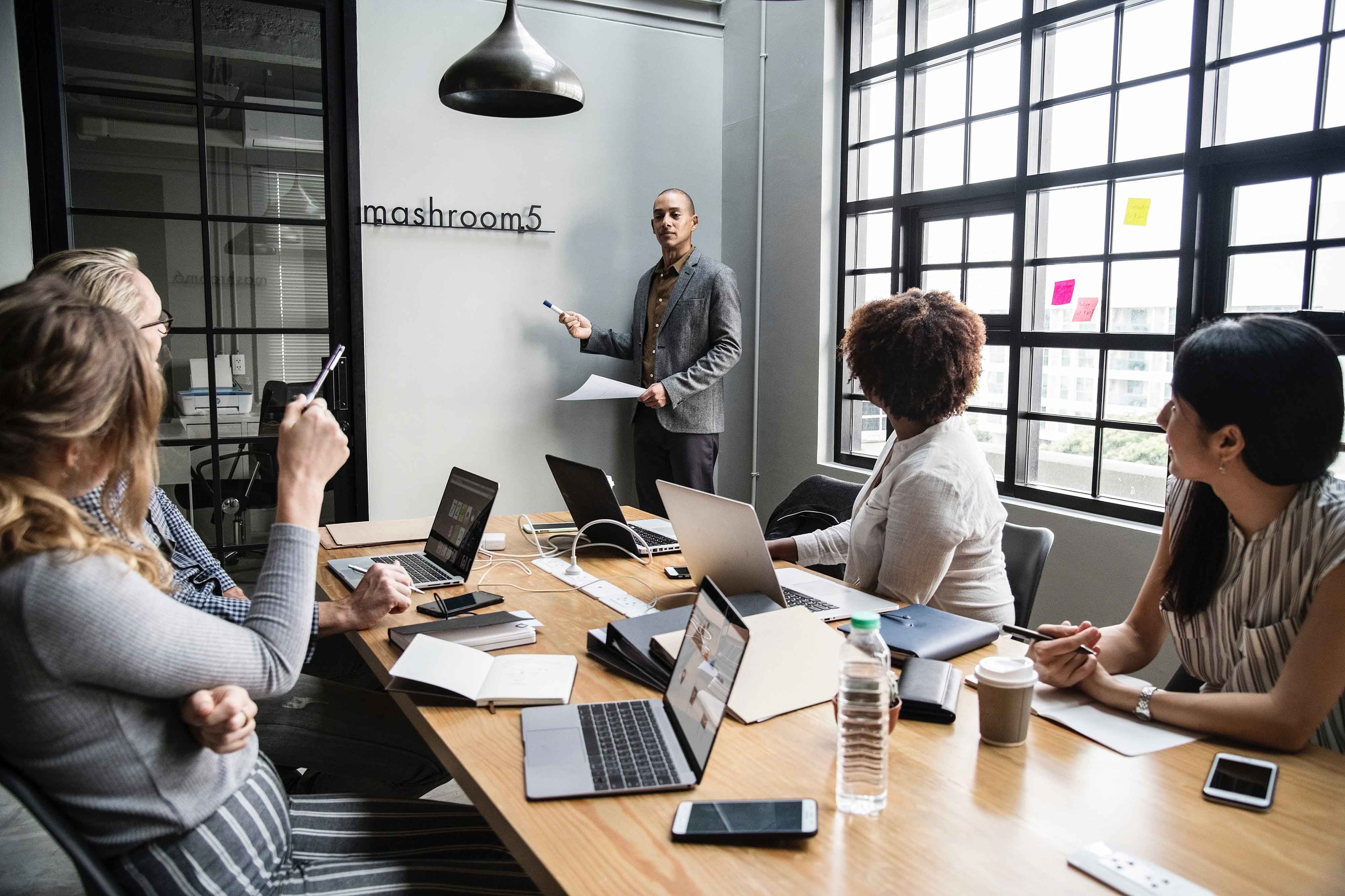 Man giving a presentation to four colleagues