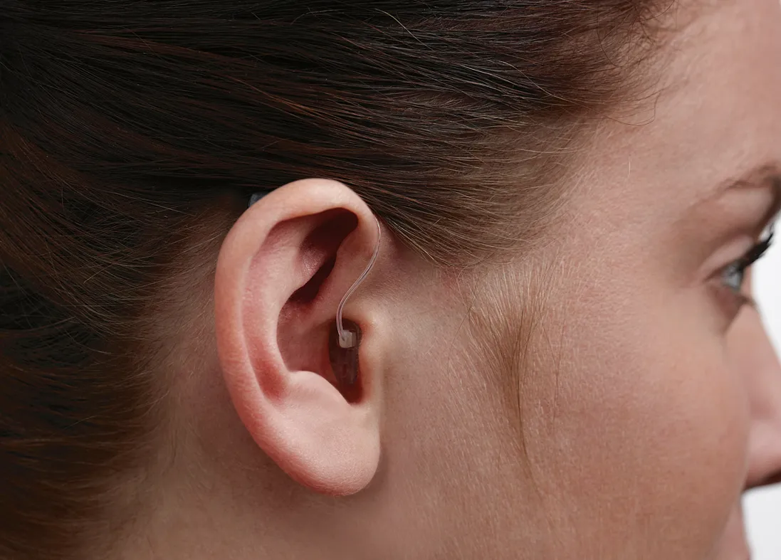 Hearing aid inserted in womans ear