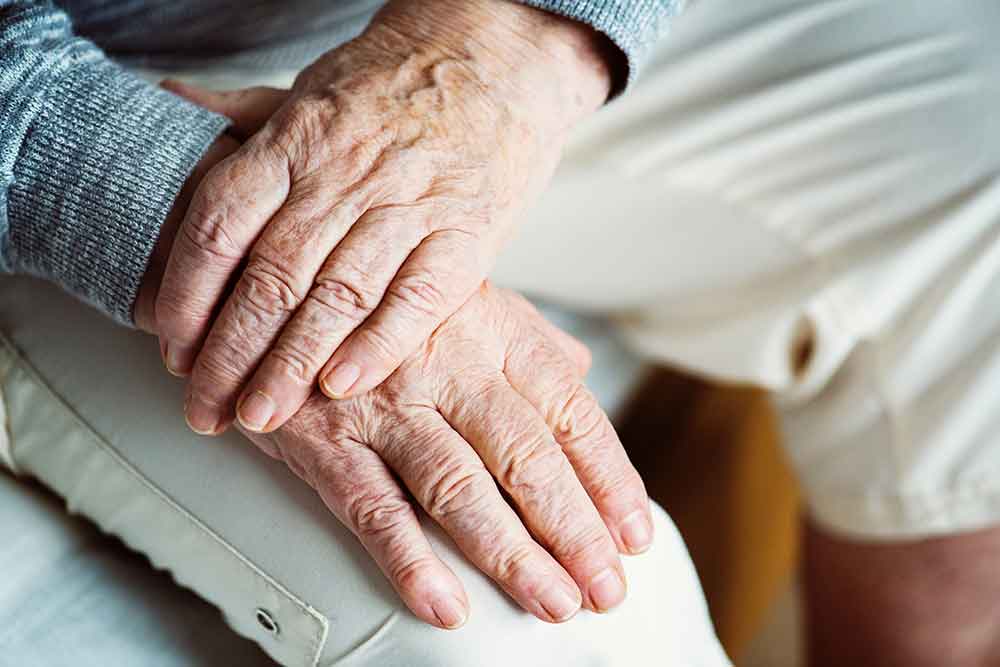 Elderly persons hands crossed