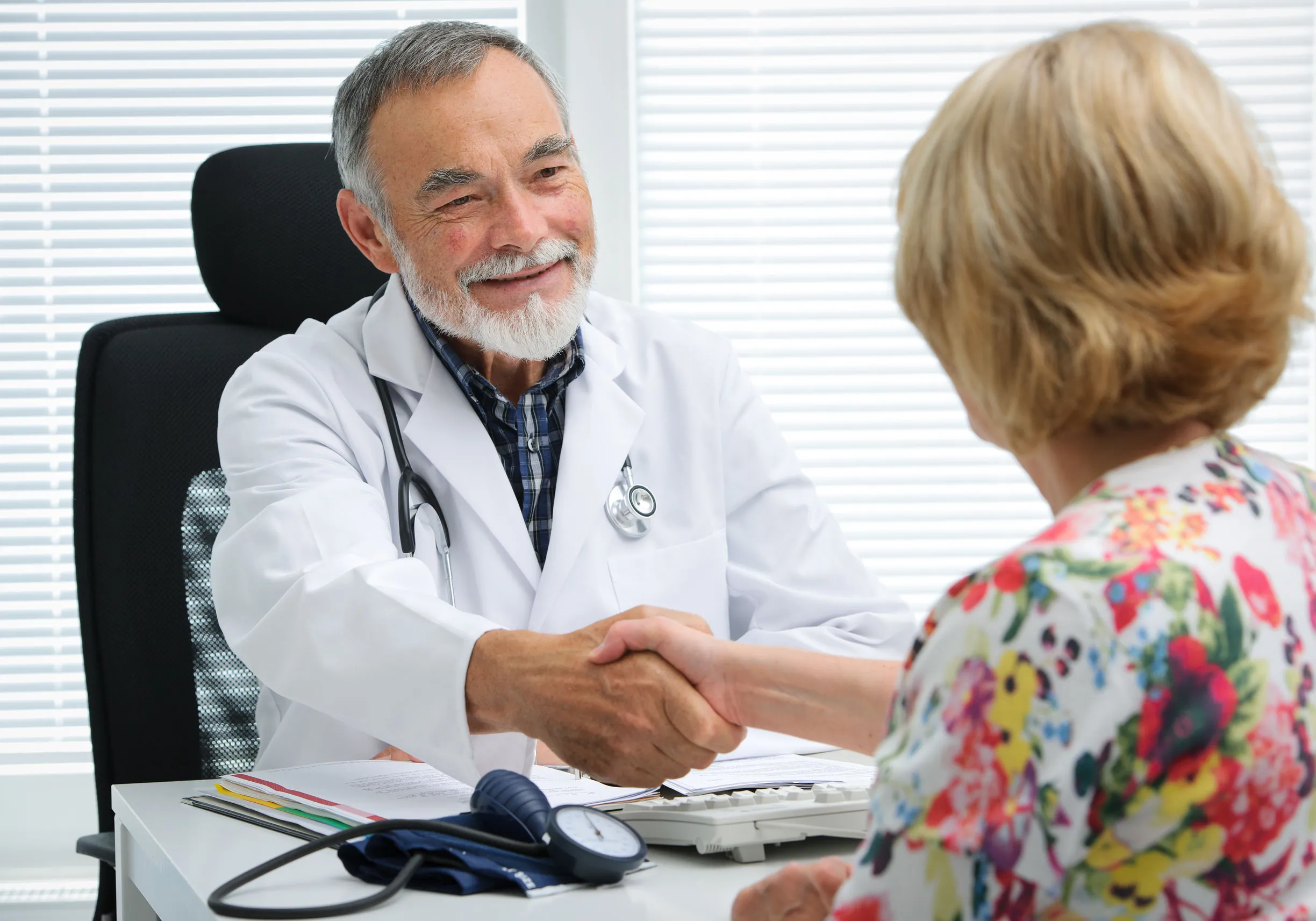 Doctor shaking hands to patient in the office|Speech therapist exercising with child in her bright office