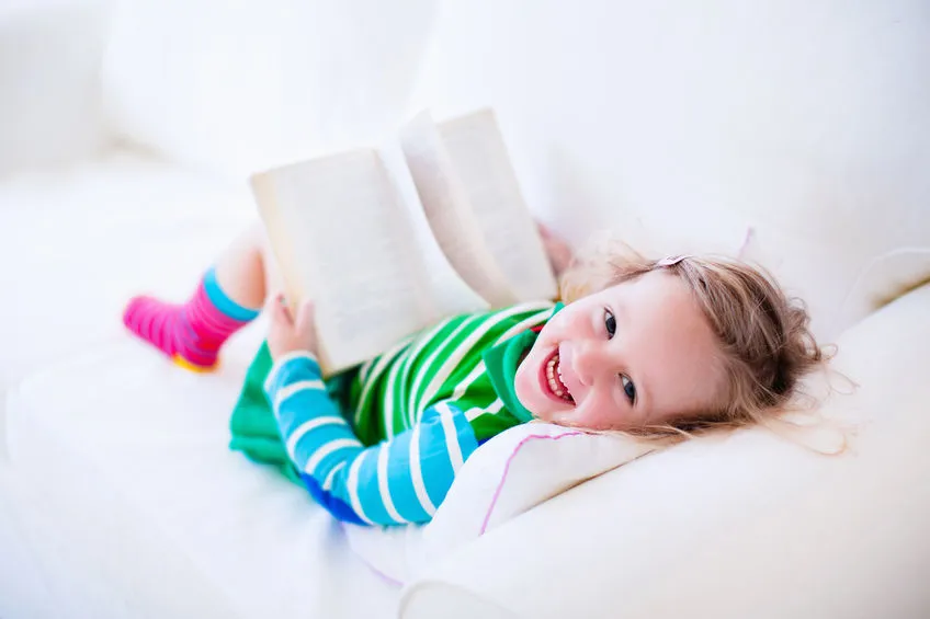 Toddler Reading a Book on Couch - SpeechEasy