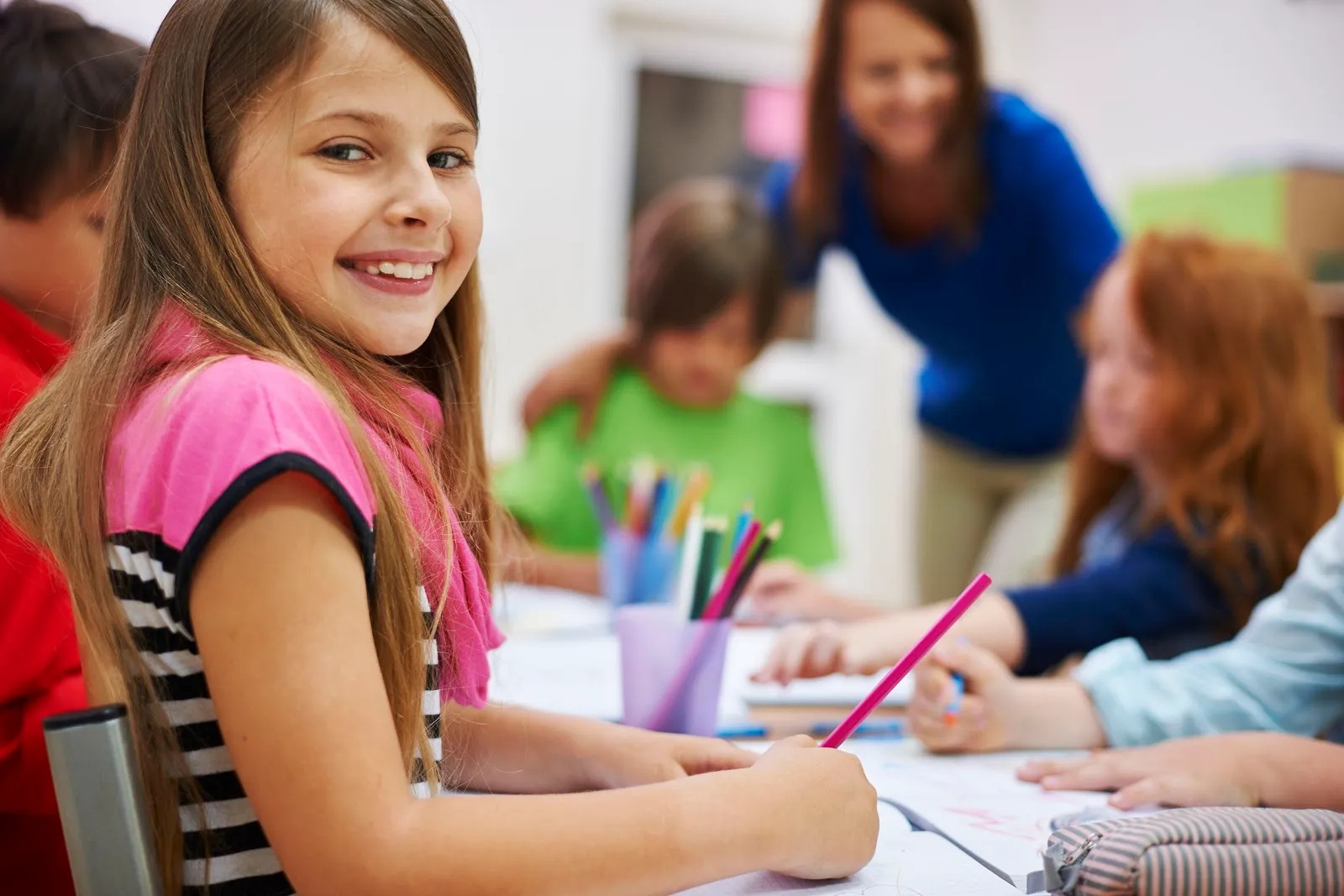 Young Girl Sitting at Desk in Classroom