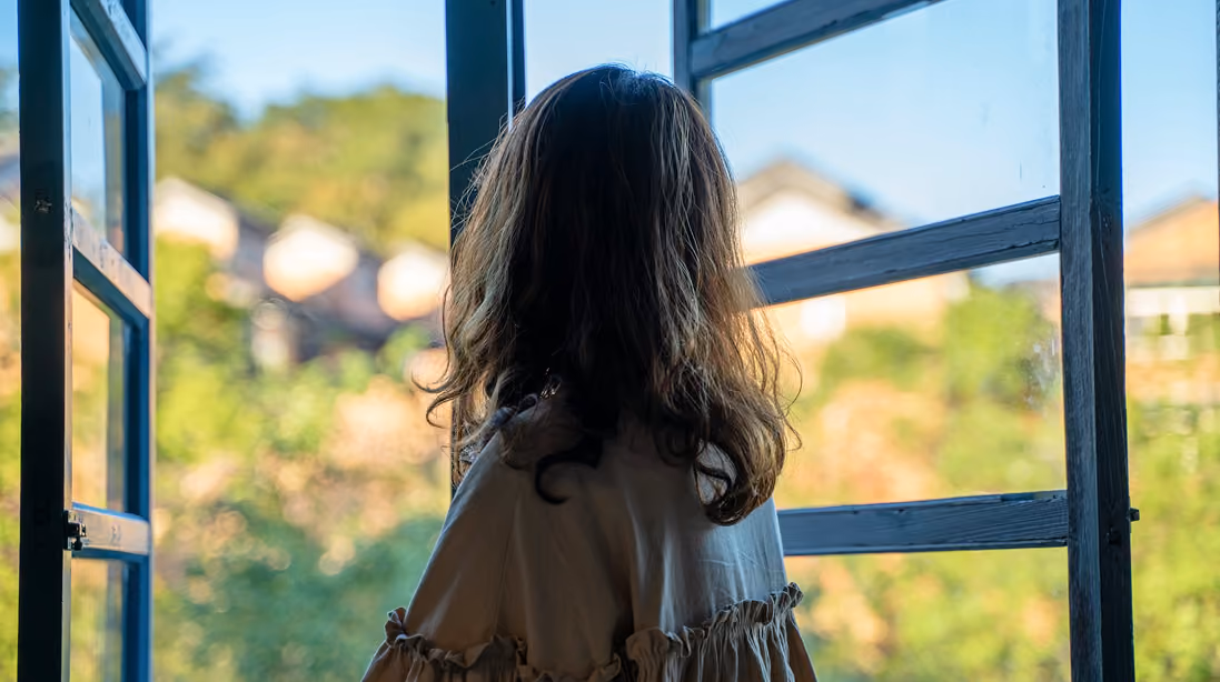 lady looking out green window