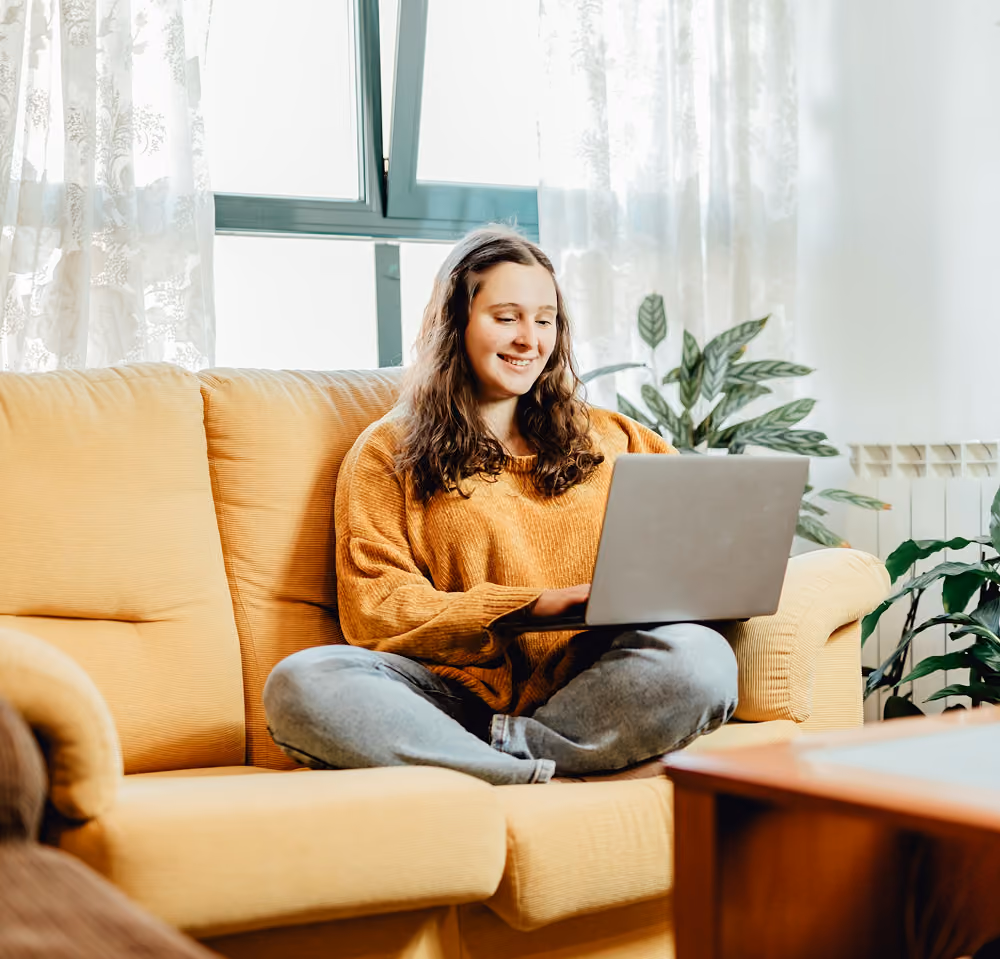 girl smiling at computer in her Thornlie apartment