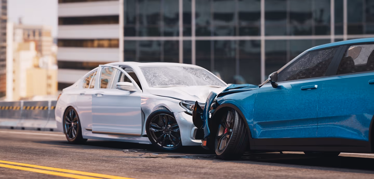 Two cars with front-end damage after a collision on a city street in daylight.