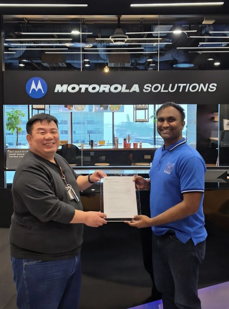 Vishnu Saran holding the signed MoU under Motorola Solutions signage